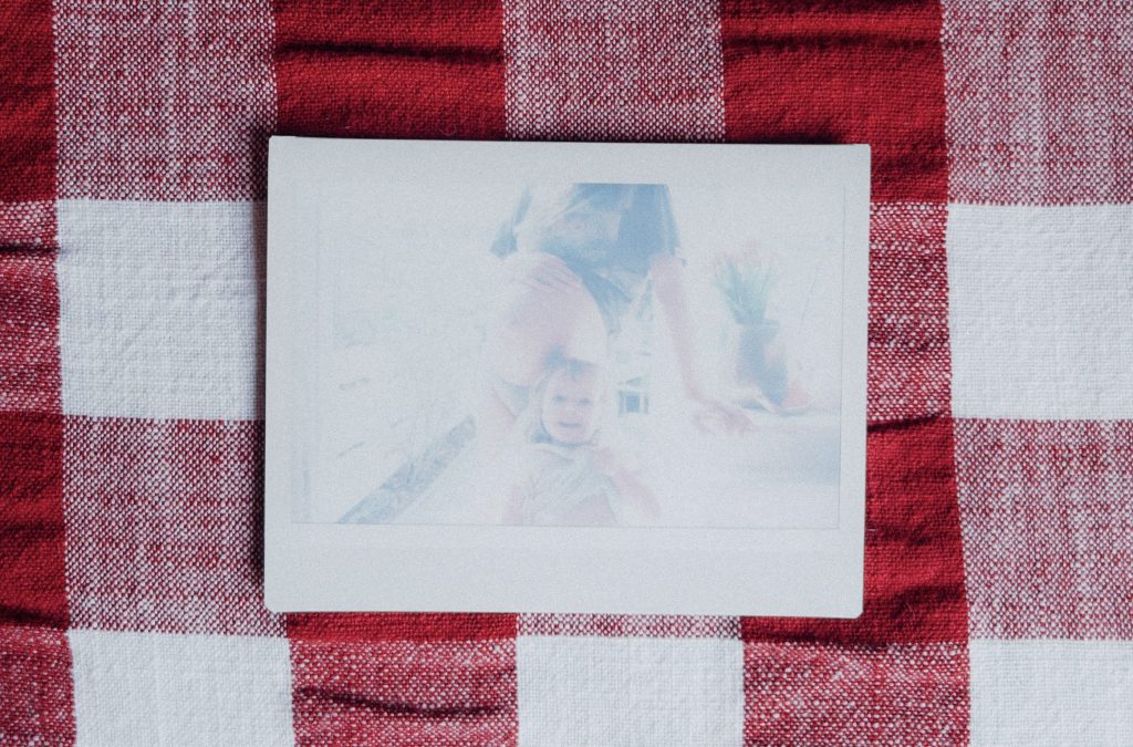 Runder Babybauch mit großer Schwester, die lacht.